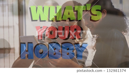 Friends holding tablet while leaning in and smiling in home seating area, with hobby text overlay Friends holding tablet while leaning in and smiling in home seating area, with hobby text overlay 132981374