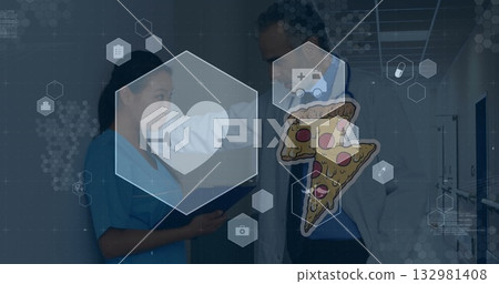 Doctor wearing lab coat and scrub nurse reviewing tablet in hospital corridor with hexagon icons Doctor wearing lab coat and scrub nurse reviewing tablet in hospital corridor with hexagon icons 132981408