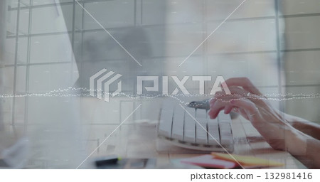 Typing hands tapping on white keyboard on office desk, with pens sticky notes window grid overlay 132981416