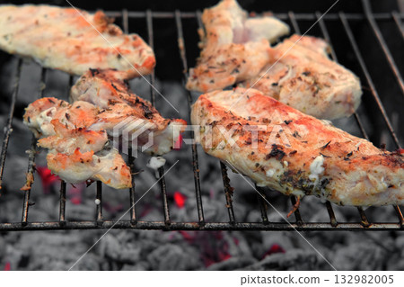 Chicken Fillet Bbq. Grilled Chicken Breast on the hot Grill with Smoke and Fire Flames. Juicy White Meat Steak. Delicious Poultry Roasted Cooked on a Charcoal Barbecue. Camping Food. Outdoors Cooking 132982005