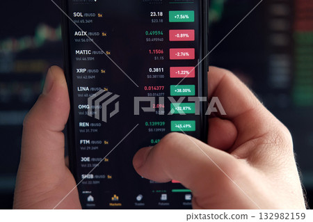 Businessman trader using smartphone checking stock exchange. Man using mobile phone with investing application. Stock market investment and trading cryptocurrency on app in hand. Online business data Businessman trader using smartphone checking stock exchange. Man using mobile phone with investing application. Stock market investment and trading cryptocurrency on app in hand. Online business data 132982159
