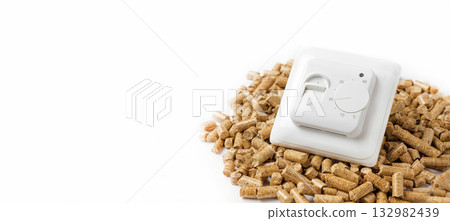 Wooden Pellets with Thermostat. Thermostatic Valve Head Isolated on White Background. Renewable Source of Heating. Biofuel. Ecologic Fuel made from Biomass. The Alternative Energy Source. Gas Crisis. 132982439
