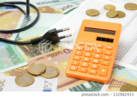 Power plug and Calculator on Euro Banknotes Background. Increasing Consumption. Cost of Electricity, Expensive Energy Concept. Price Hike. Heating Crisis. Utility Bill Saving, Conservation. Inflation Power plug and Calculator on Euro Banknotes Background. Increasing Consumption. Cost of Electricity, Expensive Energy Concept. Price Hike. Heating Crisis. Utility Bill Saving, Conservation. Inflation 132982453