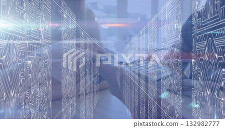 Typing IT professional blending laptop hardware with data overlays in server room, circuit board 132982777