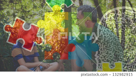 Smiling father and son sharing moment on sunlit clearing, with colorful puzzle maze graphics Smiling father and son sharing moment on sunlit clearing, with colorful puzzle maze graphics 132982915