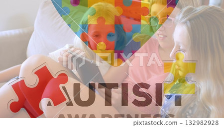Sharing three preteen girls examining tablet on living room sofa, with autism awareness puzzle 132982928