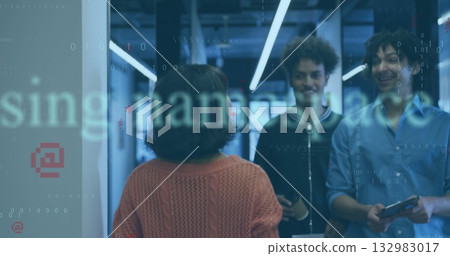 Three co-workers exchanging code in office corridor, with smartphone, tablet, coffee cup, badge Three co-workers exchanging code in office corridor, with smartphone, tablet, coffee cup, badge 132983017