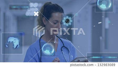 Holding tablet nurse in blue scrubs viewing holographic globe and circular charts in ward corridor Holding tablet nurse in blue scrubs viewing holographic globe and circular charts in ward corridor 132983089