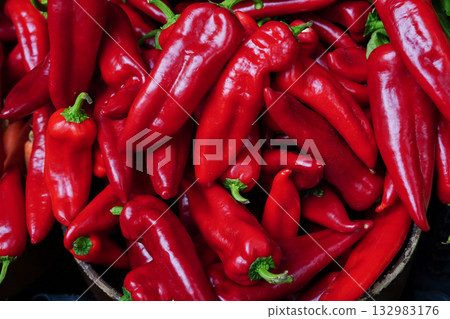Fresh red chili peppers piled together at market stall Fresh red chili peppers piled together at market stall 132983176