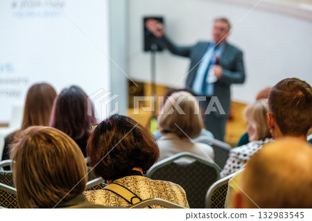 Business conference speaker presents to attentive audience during professional seminar Business conference speaker presents to attentive audience during professional seminar 132983545