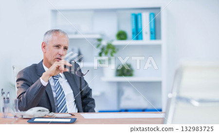 Senior man wearing business suit sitting at desk in office holding eyeglasses, copy space Senior man wearing business suit sitting at desk in office holding eyeglasses, copy space 132983725