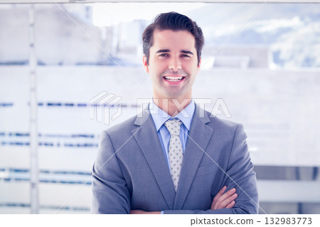 Man standing with arms crossed in business attire on office rooftop terrace by glass railing Man standing with arms crossed in business attire on office rooftop terrace by glass railing 132983773