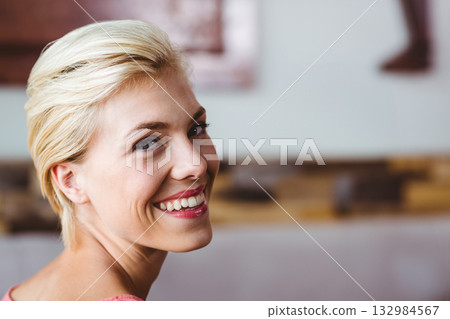 Woman smiling, looking over shoulder in spa room wearing pink robe with rolled towels, copy space Woman smiling, looking over shoulder in spa room wearing pink robe with rolled towels, copy space 132984567
