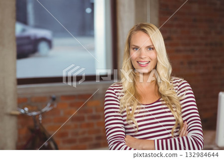 Woman in striped top smiling in office by bicycle and window showing car, copy space Woman in striped top smiling in office by bicycle and window showing car, copy space 132984644