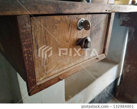 Locked money storage rack or drawer with key used in Indian shops for securing daily cash collections, commonly found in local retail stores or rural general stores 132984801