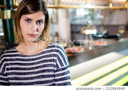 Woman standing by bar counter in cozy bar with illuminated panels and brass taps, copy space Woman standing by bar counter in cozy bar with illuminated panels and brass taps, copy space 132984840
