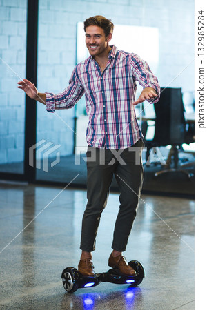 Man balancing on hoverboard inside modern office on polished concrete floor with glowing LED lights 132985284