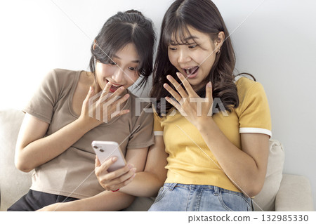 Excited Asian female students watching the smart phone 132985330