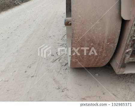 Close-up view of heavy-duty road roller wheel used in road construction, showing textured metal surface, machinery details, and industrial equipment for compacting asphalts Close-up view of heavy-duty road roller wheel used in road construction, showing textured metal surface, machinery details, and industrial equipment for compacting asphalts 132985371