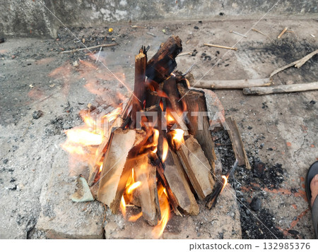Burning wooden sticks during winter season for warmth in rural area, traditional method to create heat using small fire from dry wood pieces for surviving cold night in countryside Burning wooden sticks during winter season for warmth in rural area, traditional method to create heat using small fire from dry wood pieces for surviving cold night in countryside 132985376