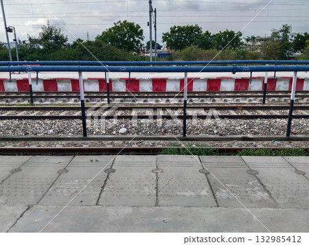 Old-style water filling pipe for trains on railway track viewed from platform, historic railway equipment used to refill locomotive water tanks, Indian Railways infrastructure 132985412