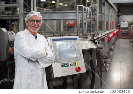 Senior technician wearing lab coat crossing arms at touchscreen panel on conveyor belt, copy space 132985496