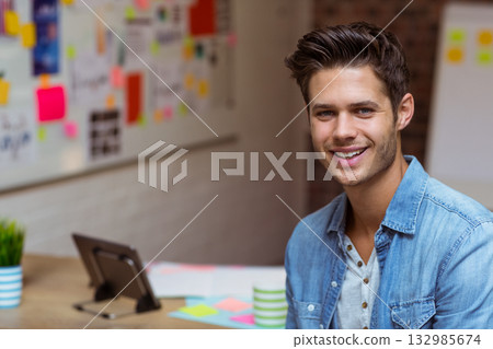 Man standing at wooden desk by whiteboard in office using tablet and sticky notes, copy space Man standing at wooden desk by whiteboard in office using tablet and sticky notes, copy space 132985674