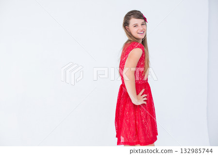 Woman posing in red lace dress with red hair bow on white studio background, copy space Woman posing in red lace dress with red hair bow on white studio background, copy space 132985744