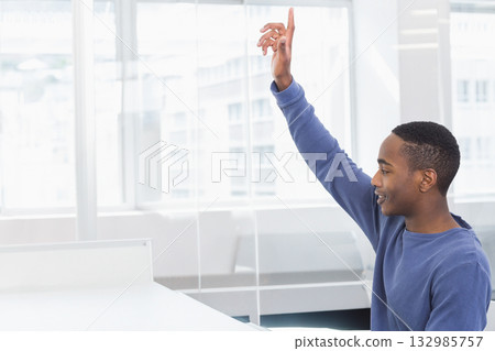 African American man raising hand while sitting at desk in office with glass partition, copy space 132985757
