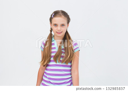 Girl standing in studio wearing pastel-clip side plaits and striped lavender mint polo shirt Girl standing in studio wearing pastel-clip side plaits and striped lavender mint polo shirt 132985837