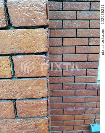 Close-up view of colonial-style red brick wall showing aged texture, earthy tone, and traditional handmade construction detail in natural light, perfect for vintage architecture background Close-up view of colonial-style red brick wall showing aged texture, earthy tone, and traditional handmade construction detail in natural light, perfect for vintage architecture background 132986231
