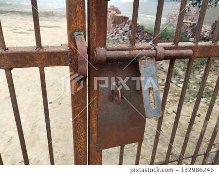 Close-up view of traditional iron mesh gate with welded reinforcement and visible locking part, highlighting rural hand-forged metalwork and craftsmanship used in local household boundaries 132986246