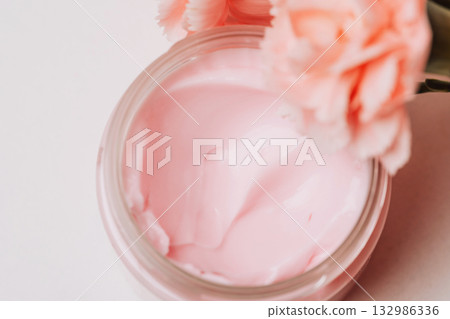Open jar with pink cream and flowers Open jar with pink cream and flowers 132986336