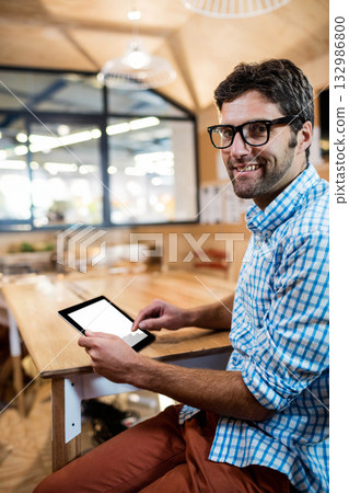 Man using tablet at wooden table by glass partition in modern shared office, copy space 132986800