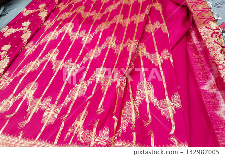 Traditional Indian ethnic fabric with golden embroidery on pink cloth  bridal dress material with intricate zari design and floral patterns for saree or salwar kameez. 132987005