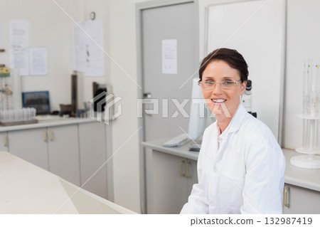 Female lab technician analyzing test tubes near microscope at laboratory bench, copy space Female lab technician analyzing test tubes near microscope at laboratory bench, copy space 132987419