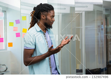 African American man gesturing while brainstorming in office with colorful sticky notes, copy space 132987496