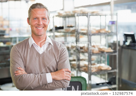 Man standing in bakery sporting business attire by metal shelving with pastries, copy space Man standing in bakery sporting business attire by metal shelving with pastries, copy space 132987574