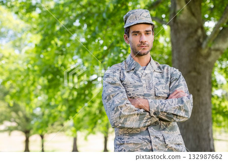 Male soldier standing in wooded area wearing camouflage jacket and patrol cap, copy space Male soldier standing in wooded area wearing camouflage jacket and patrol cap, copy space 132987662
