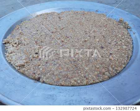 Traditional Indian peanut halwa spread on metal plate for cooling, rich dessert made with mungfali, sugar, and ghee, popular sweet during festivals and special rural occasions 132987724