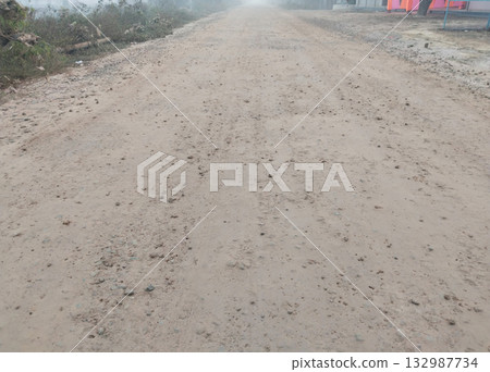 Initial stage of rural road construction with freshly laid concrete layer and water sprinkling for surface settling, part of multi-layer road building process in India Initial stage of rural road construction with freshly laid concrete layer and water sprinkling for surface settling, part of multi-layer road building process in India 132987734