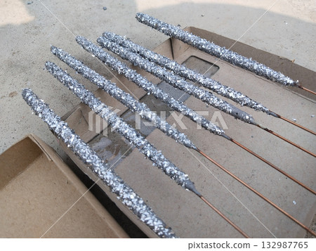 Close-up of multiple unused Diwali sparklers scattered on ground surface, unboxed fireworks with colorful sticks lying on floor before use during Indian festive preparation scene Close-up of multiple unused Diwali sparklers scattered on ground surface, unboxed fireworks with colorful sticks lying on floor before use during Indian festive preparation scene 132987765