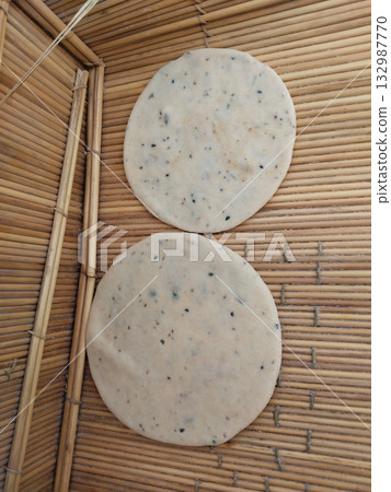 Raw sattu puri preparation on flat surface before frying, uncooked stuffed Indian bread rolled and ready for deep frying, traditional Bihar-style dish in rustic homemade kitchen setup Raw sattu puri preparation on flat surface before frying, uncooked stuffed Indian bread rolled and ready for deep frying, traditional Bihar-style dish in rustic homemade kitchen setup 132987770