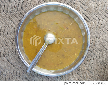 Cooked urad dal served in a traditional bowl, showcasing rich Indian lentil preparation with creamy texture and aromatic spices, representing authentic homemade vegetarian cuisine 132988312