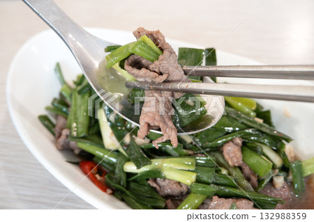 Stir-fried beef with scallions, green onions, leeks, beef. 132988359