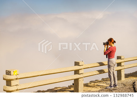 Woman with camera in mountains take travel photo 132988745