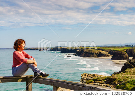 Woman visiting Cathedral Beach in Spain. 132988760