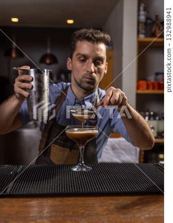 Bartender carefully pouring an ingredient 132988941