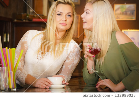 Two women sitting at cafe counter. Two women sitting at cafe counter. 132989023