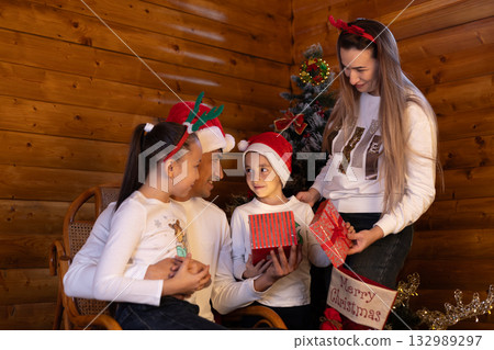 A family is gathered together, exchanging Christmas presents A family is gathered together, exchanging Christmas presents 132989297